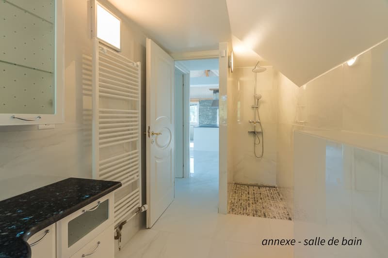 white walls, white tiled floor, white cabinets, countertop with black stone, toilet, shower, open door, glass window