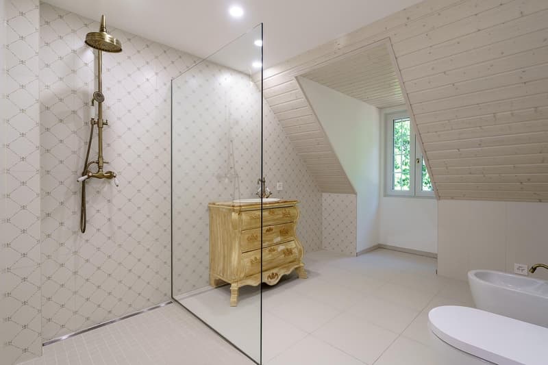 a small bathroom with a shower, a wooden chest, a sink, a bathtub and a toilet