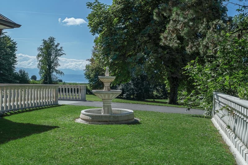 well maintained lawn, fountain, walkway, and view of mountains