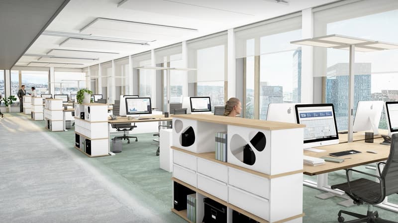 Spacious open-plan office with large windows offering a view of the city skyline. The office features modern workstations with computers, storage units, and ergonomic chairs. The overall design is minimalist and clean, creating a professional and producti