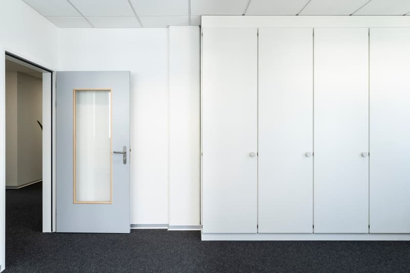 empty room, white door, white walls, gray floor, white cabinets