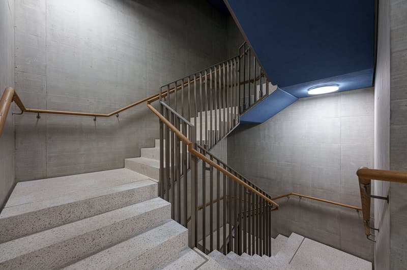 modern staircase with white marble steps, metal handrails, blue ceiling