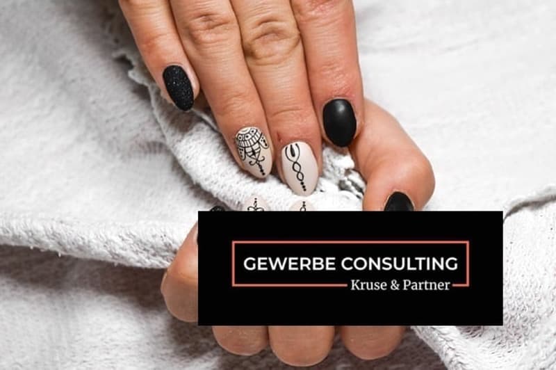 Manicured nails with black and white nail art design.