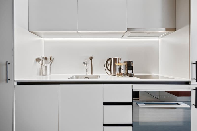 modern kitchen, white cabinets, stainless steel appliances, gas stove, built-in oven, dishwasher, washing machine, kitchen island