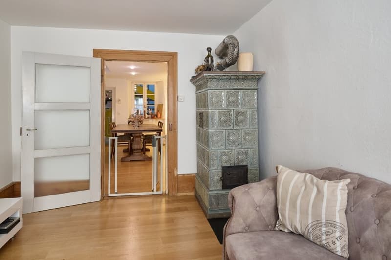 tiled fireplace, open door, wooden floor, couch, pillow, dining table