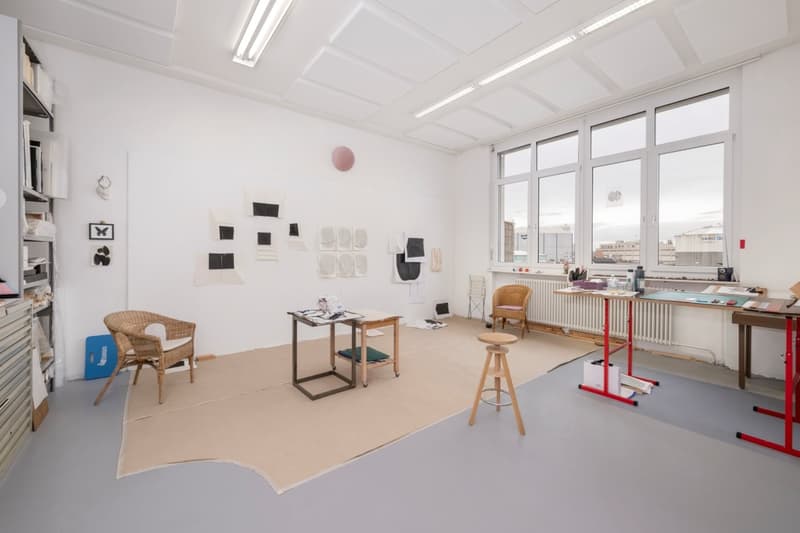 empty room, white walls, wooden chairs, tables, radiator, large windows, beige carpet