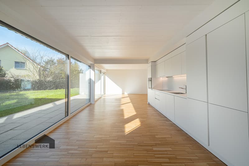 Grosszügiger Wohn- und Essbereich mit bodentiefen Fensterfronten und direktem Gartenzugang, klar, hell und offen gestaltet