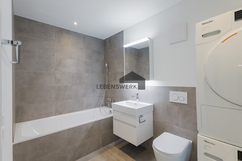 Modernes Badezimmer mit Badewanne und praktischer Waschturm-Lösung komfortabel und funktional gestaltet.