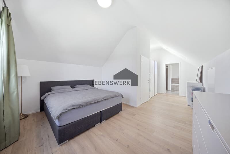 Grosszügiges Schlafzimmer im Dachgeschoss mit Masterbad auf derselben Etage.