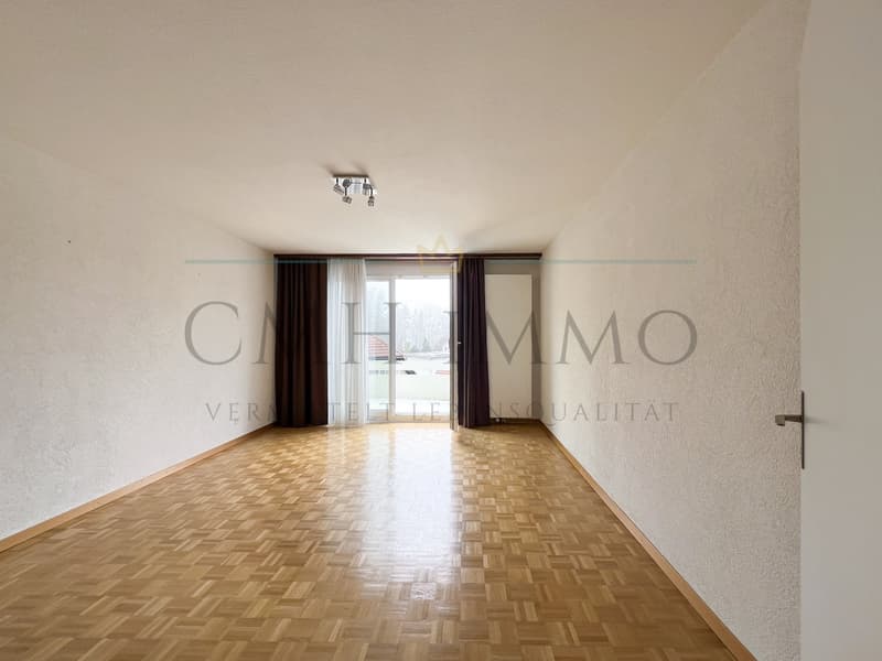 Empty room with wooden floor, white walls, sliding glass door, and ceiling lights