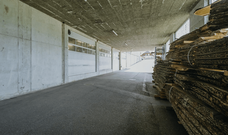 wide concrete floor, concrete walls, a stack of wooden planks