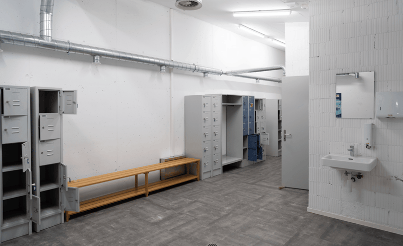 storage area with benches and lockers, white tiles, white walls, sink, mirror