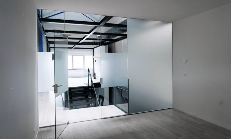 Modern room with glass wall, gray wall, white wall, and wooden floor