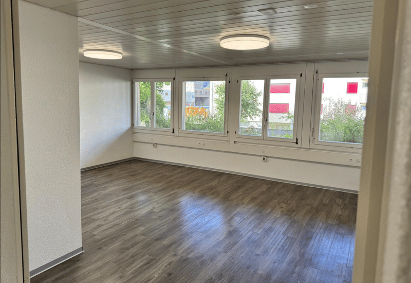empty room with wooden floor, large windows, ceiling lights