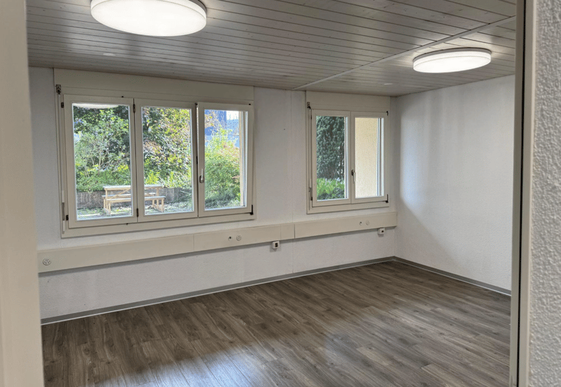 wooden floor, large windows, two lamps, view to outdoor
