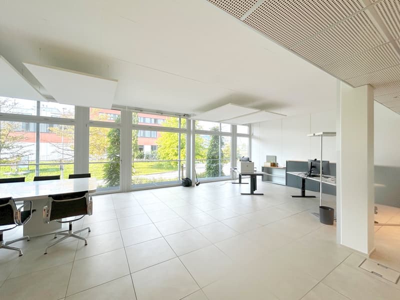 modern office room, white tiles, large windows, desks, monitors, trash bin