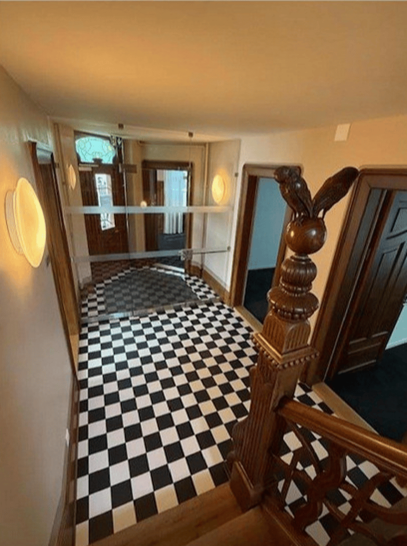 black and white checkered floor, wooden bannister, glass wall, illuminated walls