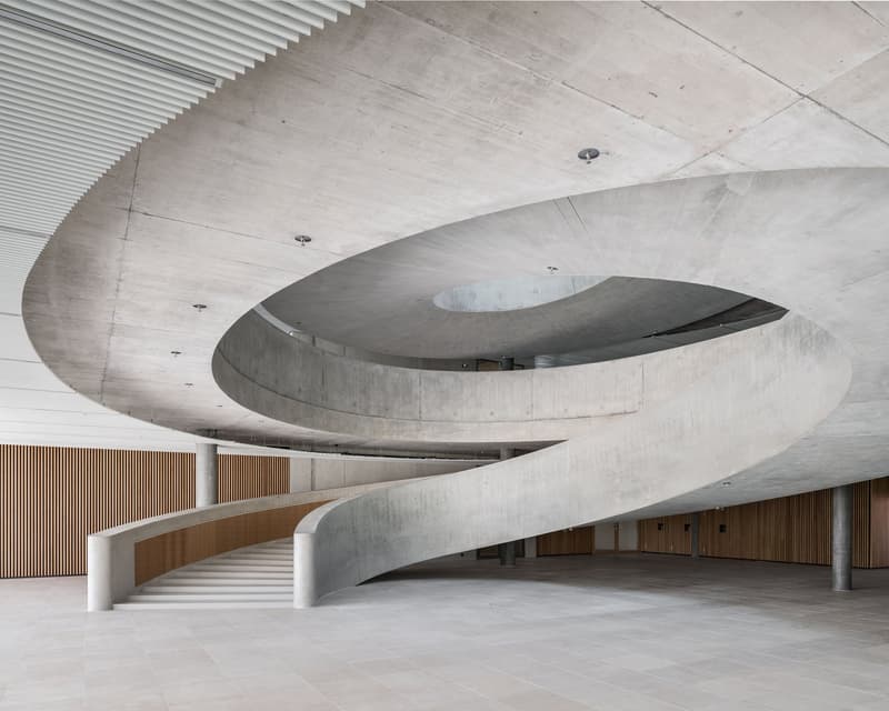 modern building, spiral staircase, white tile flooring, exposed concrete walls, open space