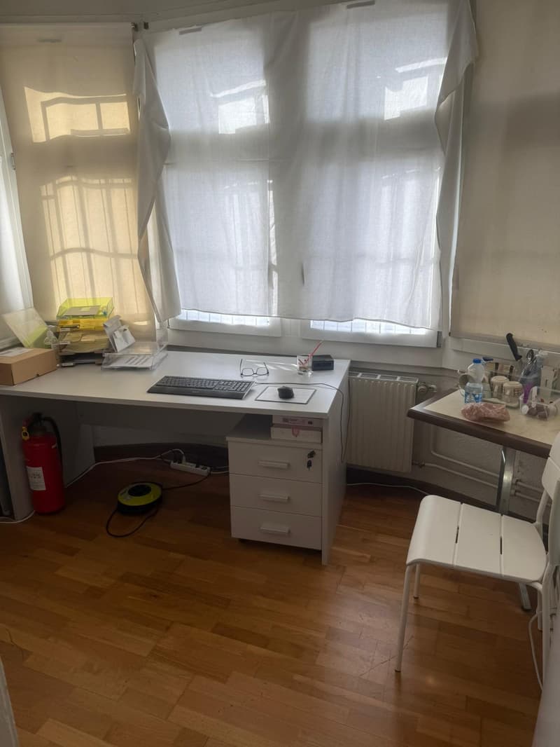 Desk, chair, fire extinguisher, books, computer, radiator, window, curtain
