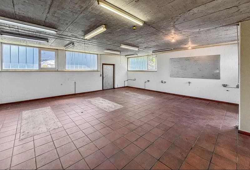 empty room with windows, white brick walls, tile floor, white ceiling, fluorescent lighting
