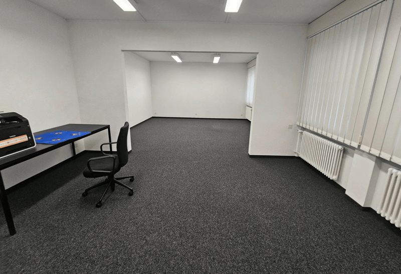 empty room with desk, chair, and printer