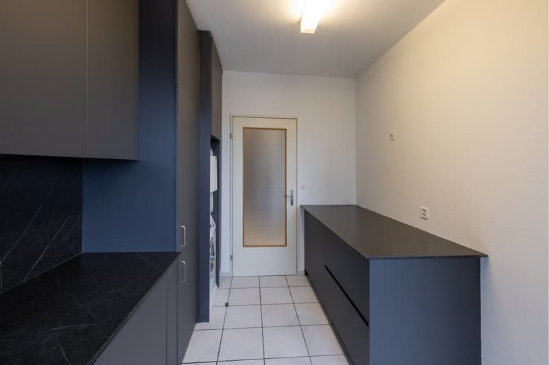 minimalistic, tile floor, white wall, two sets of cabinets, white door with glass window, washer