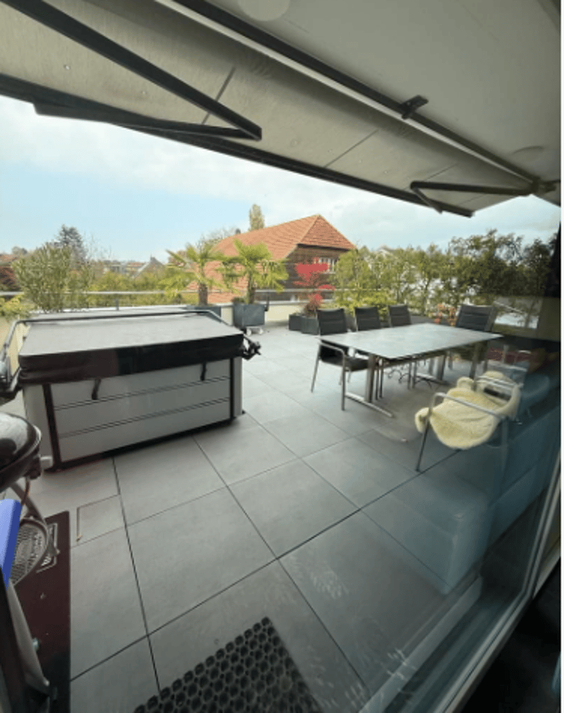Tiled floor, covered area, hot tub, table with chairs, scenic view, potted plants