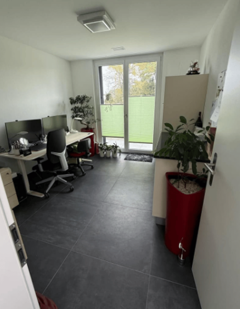 desk with computer, chairs, plant, tiled floor, ceiling light