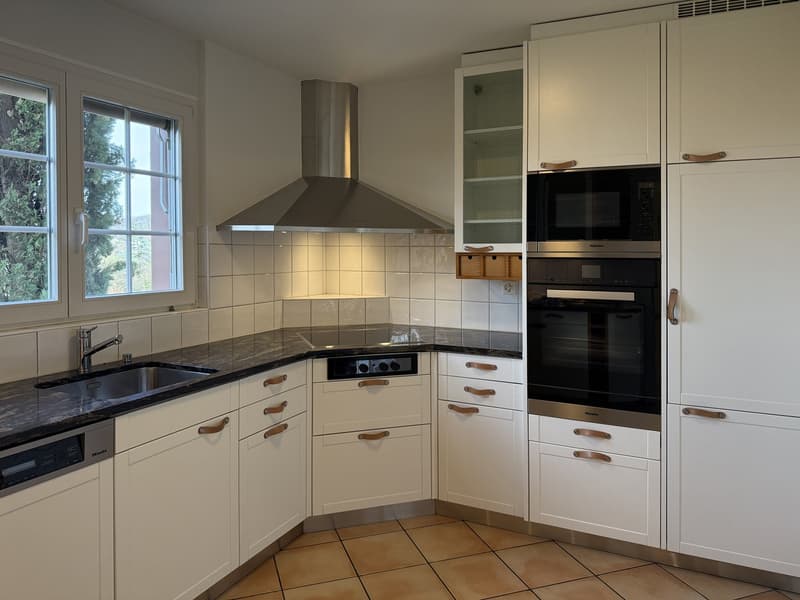 modern kitchen with white cabinets, black granite countertops, stainless steel appliances, built-in dishwasher, integrated washing machine