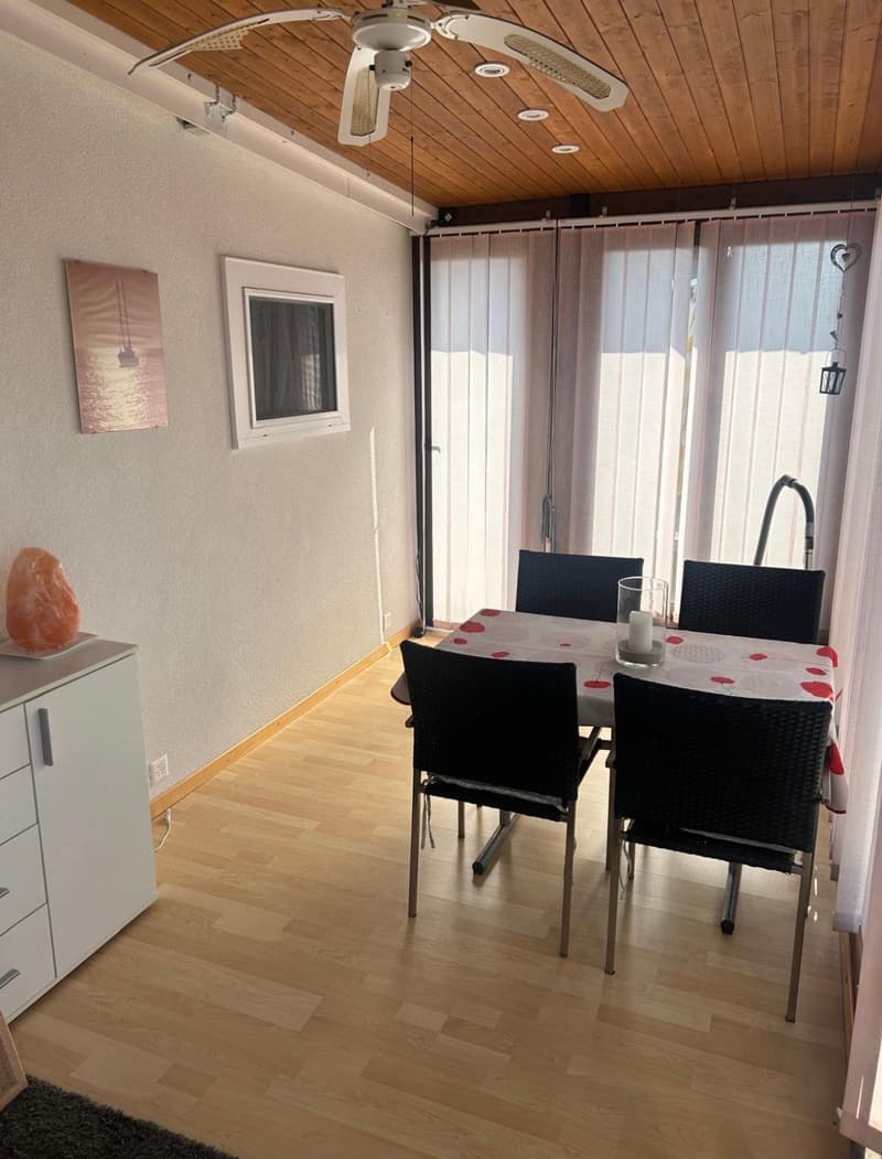 dining room with table and chairs, ceiling fan, window with blinds, artwork on wall, wooden floor, cabinet