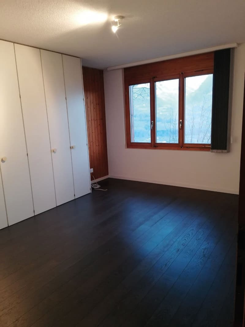 empty room, wooden floor, white walls, large window, wooden paneling, white wardrobe