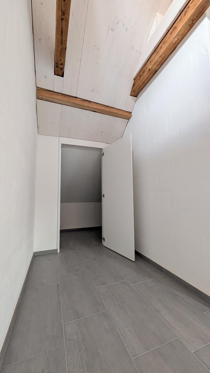 empty room, white walls, wooden beams, tiled floor, open door
