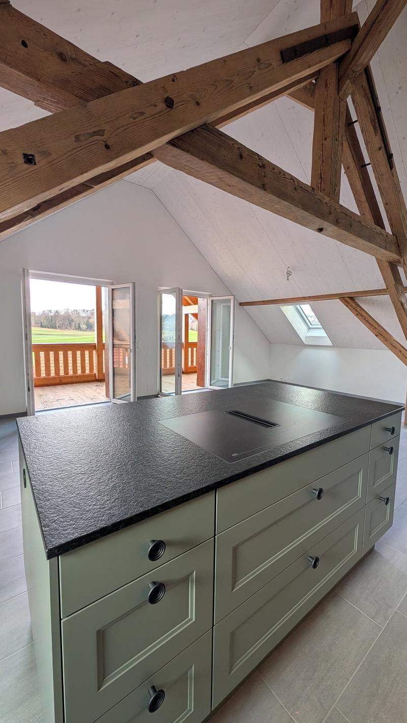 kitchen with island, wooden beams, large windows, balcony, view