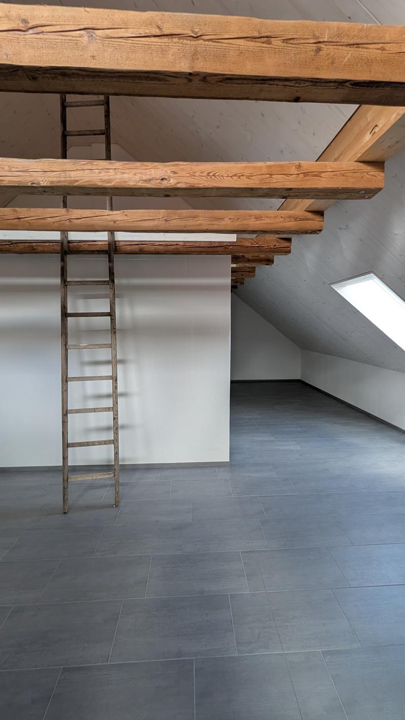 empty room, wooden beams, wooden ladder, tiled floor, white wall, skylight