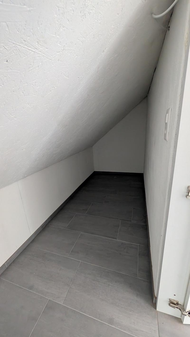 empty room, gray tiles, white walls, slanted ceiling