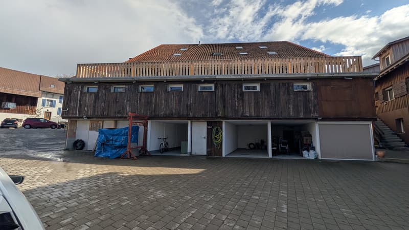 2 story house, wooden exterior, multiple garages, balcony, brick driveway