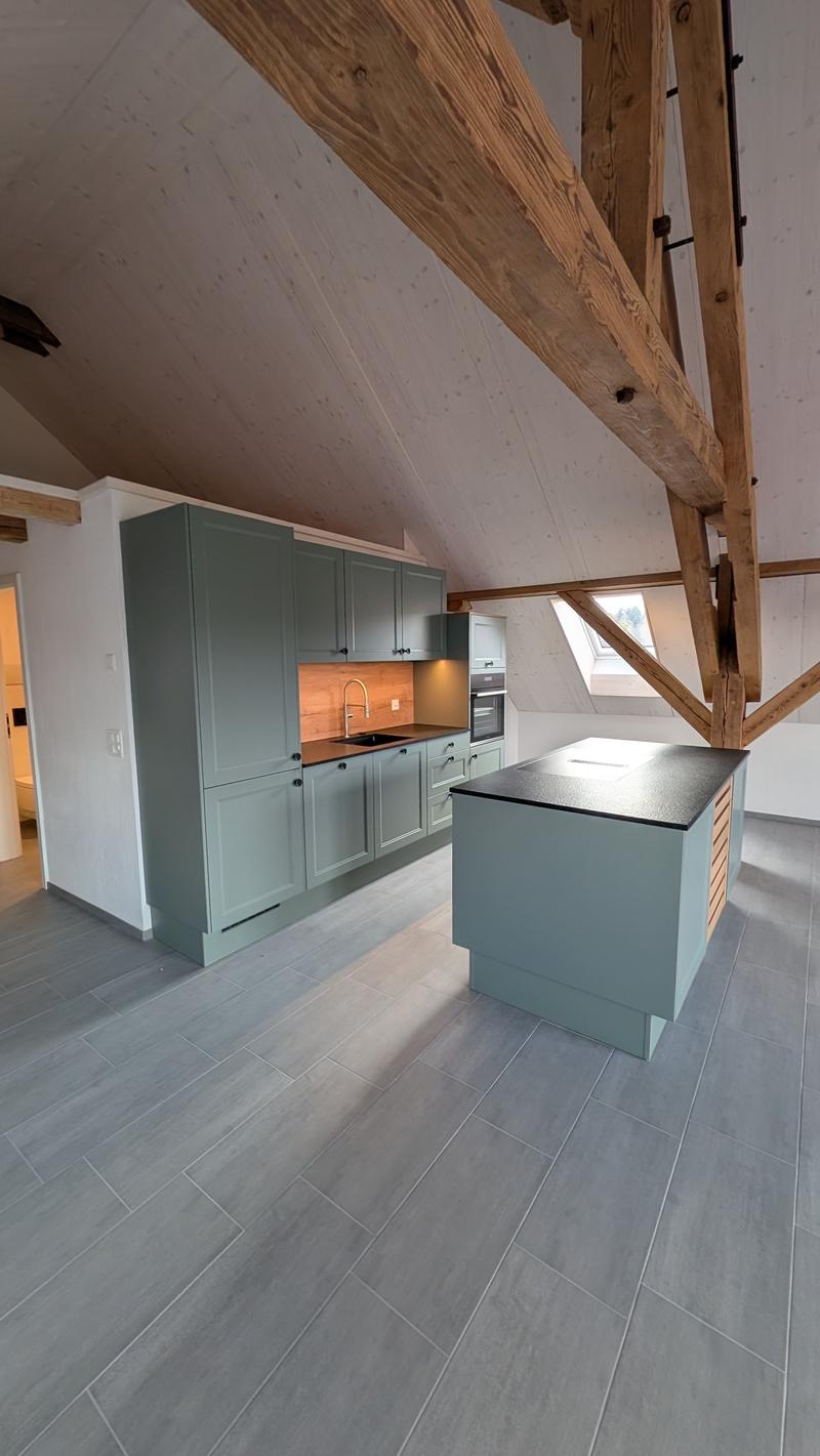 modern kitchen with wooden beams, gray cabinets, black countertop, island, sink, faucet, oven, dishwasher
