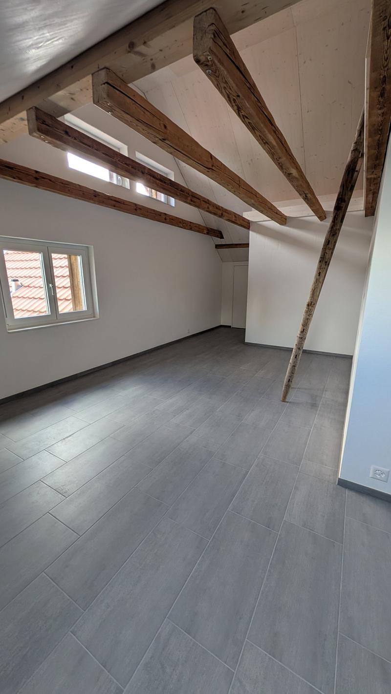 empty room, wooden beams, gray tiles, white walls, windows