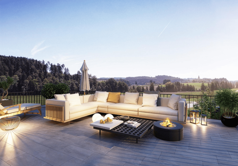 Outdoor terrace with a large sofa, coffee table, fire pit, and umbrella. The terrace has a view of the surrounding landscape.