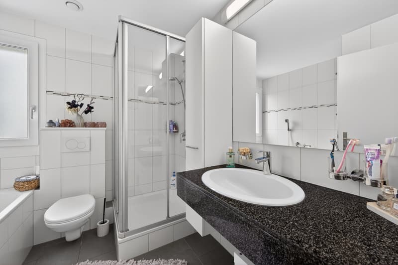 Badezimmer mit Badewanne und Duschkabine