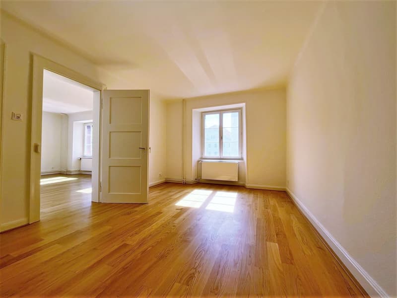empty room, wooden floors, bright windows, white walls, open door