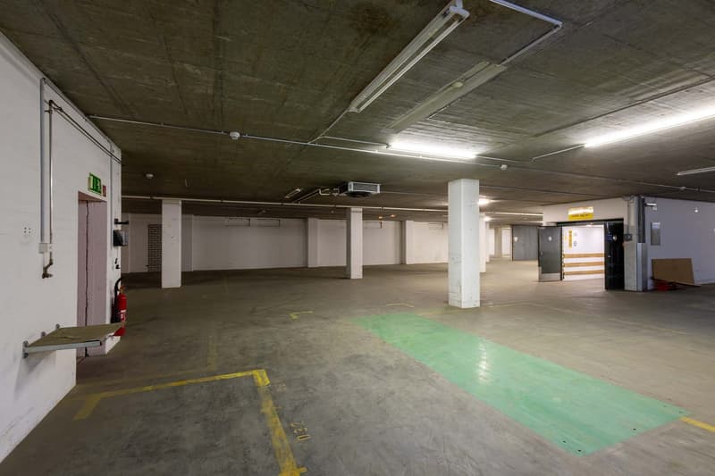 large empty parking lot with pillars, fire extinguisher, yellow parking marks