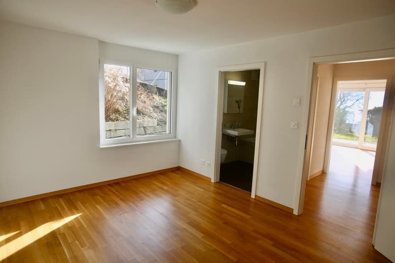 empty room, wooden floors, large window, sink, toilet
