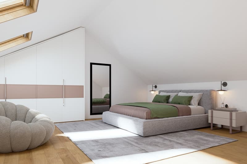 An attic bedroom with white walls, wooden flooring, a large gray bed, a mirror, a bean bag chair, a white storage cabinet, a side table, wall lamps, and skylight windows.