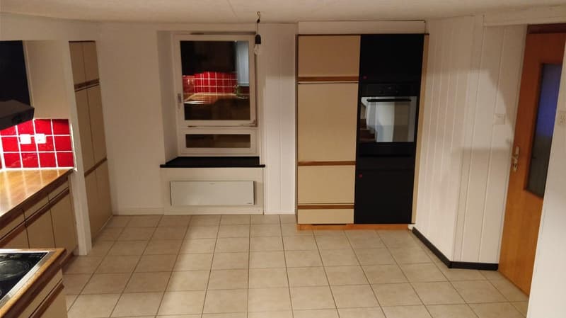 empty kitchen with wooden tiles, light colored cabinets, white walls, window, oven
