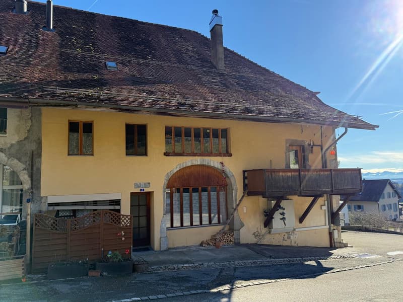 2 story house, yellow paint, brown roof, wooden balcony, chimneys, wooden fence, potted plants