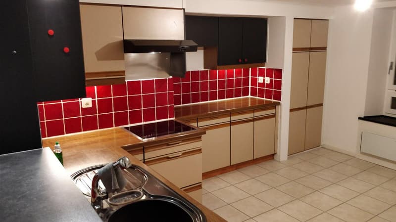 kitchen with red tiled backsplash, wooden countertops, black appliances, cabinet, sink