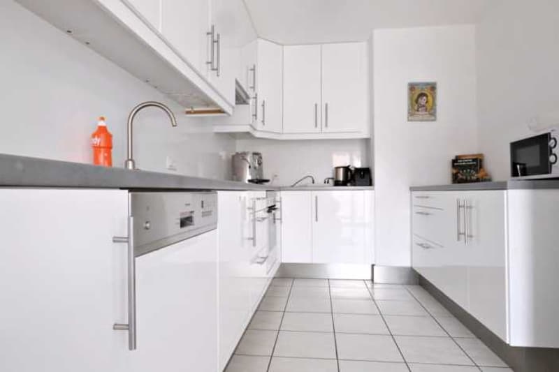 modern kitchen with white cabinetry and stainless steel appliances, dishwasher and washing machine visible
