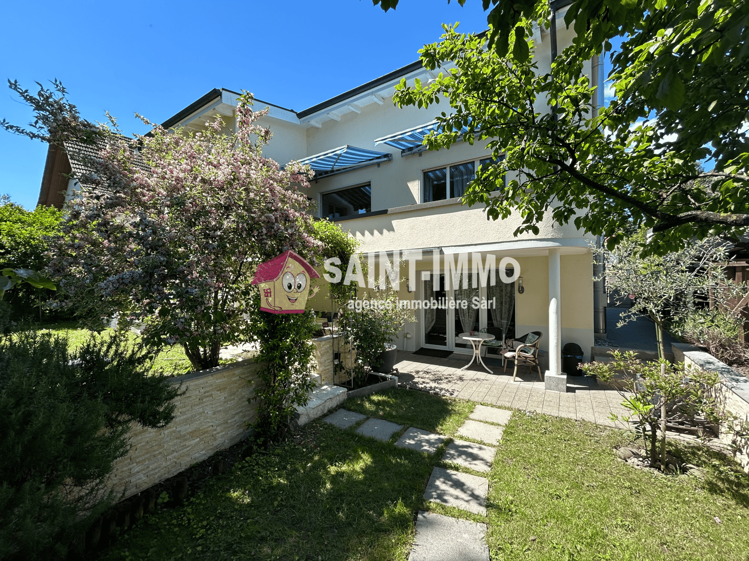 modern house with garden, paved walk way, plants and trees