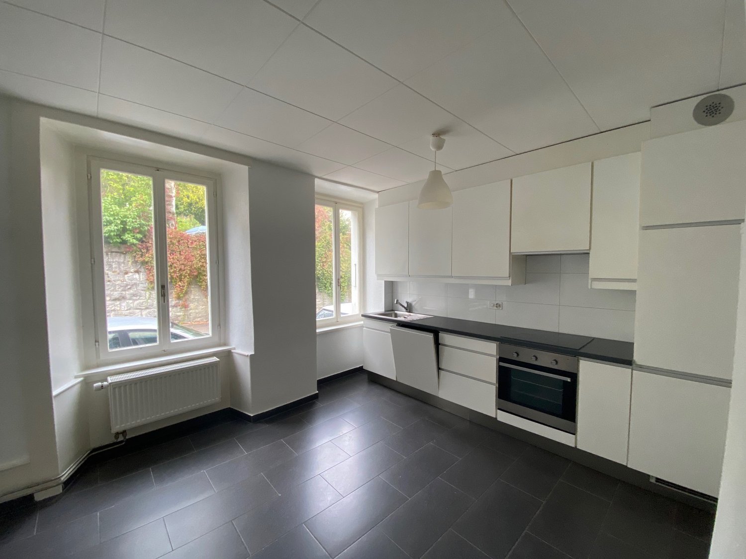 Modern open-plan kitchen with granite countertop, electric stove, oven, refrigerator, and dishwasher.